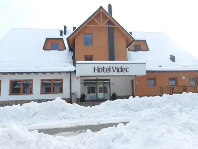 a building with lots of snow in front of it at Pohorje Village Wellbeing Resort - Forest Hotel Videc in Pohorje