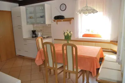 a kitchen with a table and chairs and a window at Apartment Stefelin in Kamna Gorica