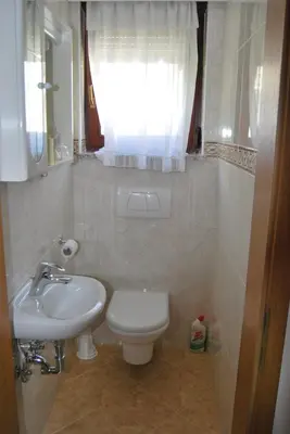 a bathroom with a sink and a toilet and a window at Apartment Stefelin in Kamna Gorica