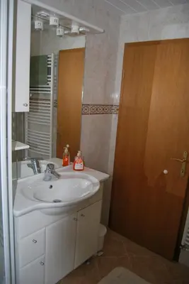 a bathroom with a sink and a mirror at Apartment Stefelin in Kamna Gorica
