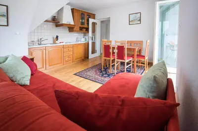 a living room with a red couch and a kitchen at Vila Katja in Bled