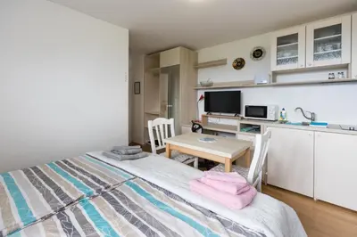 a bedroom with a bed and a table and a kitchen at Vila Katja in Bled