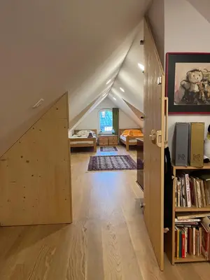 an attic room with a door and a bedroom at Vila Katja in Bled
