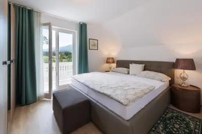 a bedroom with a large bed and a balcony at Vila Katja in Bled