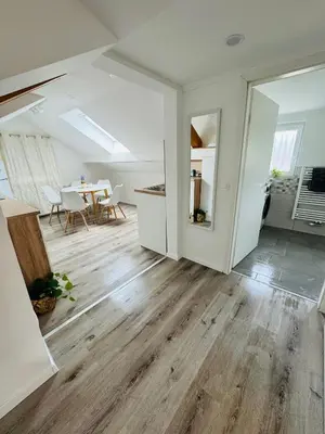 an open living room with wooden floors and a table at Aria apartment in Mošnje