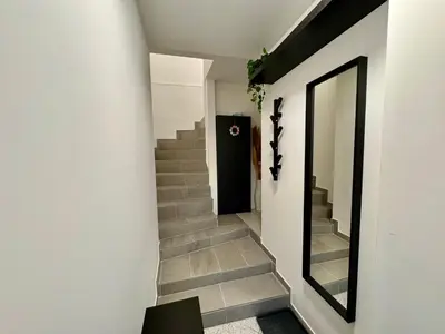 a hallway with stairs and a mirror on the wall at Aria apartment in Mošnje