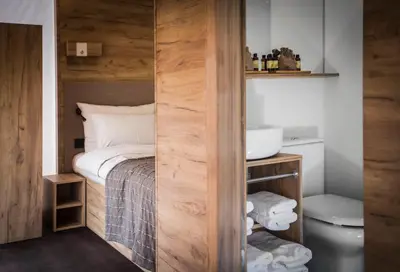 a small bathroom with a bed and a toilet at Glamping Olimia Adria village in Podčetrtek