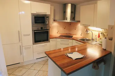 a kitchen with white cabinets and a wooden counter top at Apartma AS in Lesce