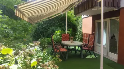 a patio with a table and chairs under awning at Apartma AS in Lesce