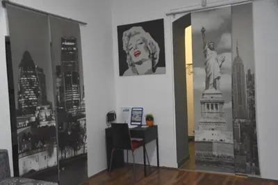 a room with a desk and a picture of the statue of liberty at CityApartment-Maribor in Maribor