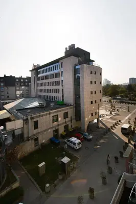 a building with a car parked in a parking lot at Apartment Eva Tour As Ljubljana in Ljubljana