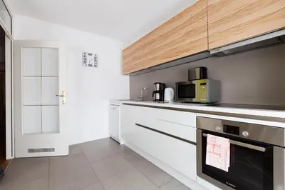 a kitchen with white cabinets and a microwave at Apartment Eva Tour As Ljubljana in Ljubljana