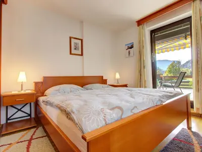 a bedroom with a large bed and a window at Apartments Orazem in Bled