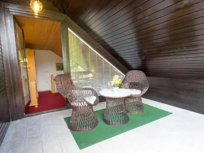 a patio with a table and chairs on a porch at Apartments Orazem in Bled