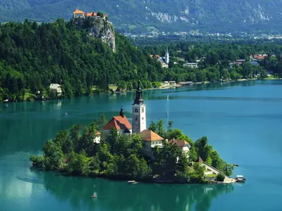 an island in the middle of a lake with a lighthouse at Apartments Orazem in Bled
