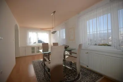 a dining room with a table and chairs and windows at Family Villa Bled in Bled