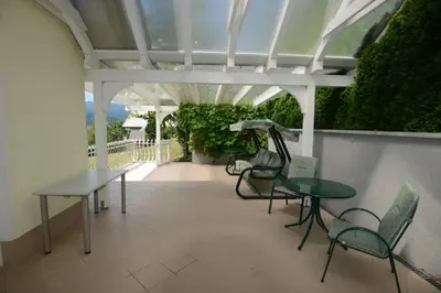 a patio with tables and chairs on a roof at Family Villa Bled in Bled