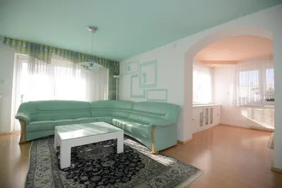 a living room with a green couch and a table at Family Villa Bled in Bled