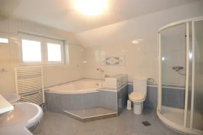 a bathroom with a tub and a toilet and a sink at Family Villa Bled in Bled