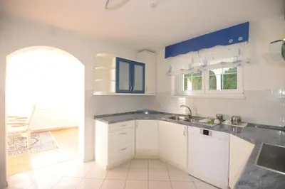 a kitchen with white cabinets and a sink at Family Villa Bled in Bled