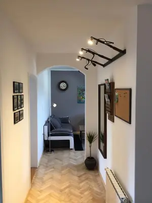 a hallway with a couch and a clock on the wall at Apartment Gondola in Maribor
