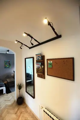 a room with a mirror and lights on a wall at Apartment Gondola in Maribor