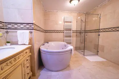 a bathroom with a tub and a shower and a toilet at Casino & Hotel ADMIRAL Skofije in Zgornje Škofije