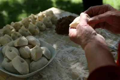 a person preparing food on a table with a bowl of food at Hotel Hvala Superior - Topli Val in Kobarid