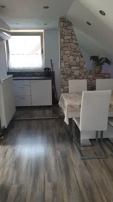 a kitchen with a table and two white chairs at Apartments & Chalet Jurček in Luče