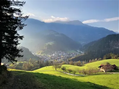 a green hillside with a town in a valley at Apartments & Chalet Jurček in Luče