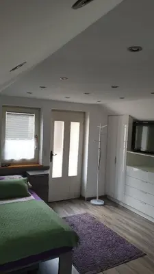 a bedroom with a bed and a window and a door at Apartments & Chalet Jurček in Luče