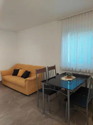 a living room with a couch and a table with chairs at Apartma Žirovnik in Cerklje na Gorenjskem