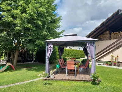 a gazebo with chairs and a table in a yard at Apartma Žirovnik in Cerklje na Gorenjskem