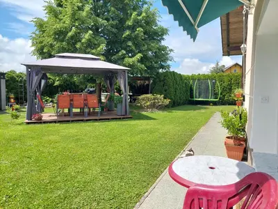 a garden with a table and a gazebo at Apartma Žirovnik in Cerklje na Gorenjskem