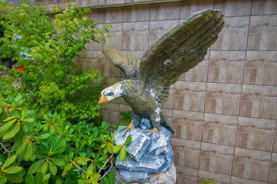 a statue of an eagle sitting on a rock at Apartments Orel in Mozirje