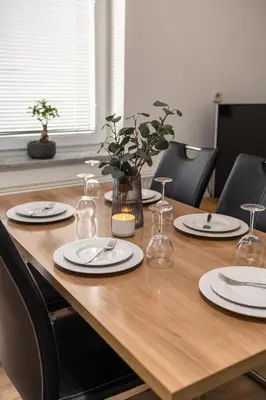a wooden table with plates and glasses on it at Apartments Orel in Mozirje