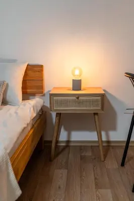 a table with a lamp on it next to a bed at Apartments Orel in Mozirje