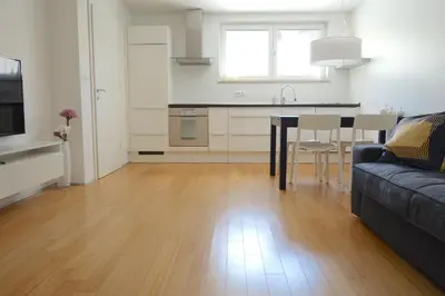 a kitchen and living room with a couch and a table at Sensei apartment in Ljubljana