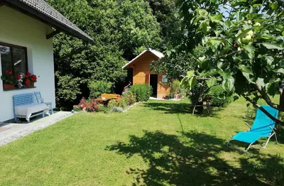 a yard with a blue chair and a house at PR`Cajhn in Radovljica