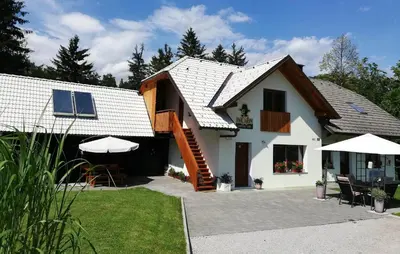 a white house with a staircase in a yard at PR`Cajhn in Radovljica