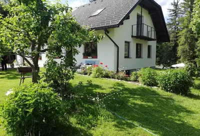 a small white house with a grass yard at PR`Cajhn in Radovljica
