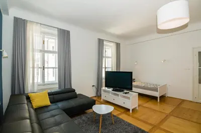 a living room with a couch and a television at Elegant Central Apartment in Ljubljana