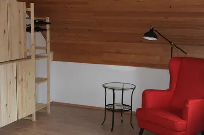 a living room with a red chair and a lamp at Holiday Home Winzerhaus Eva in Špičnik