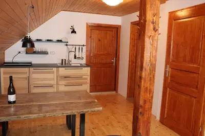 a kitchen with a wooden table with a bottle of wine at Holiday Home Winzerhaus Eva in Špičnik