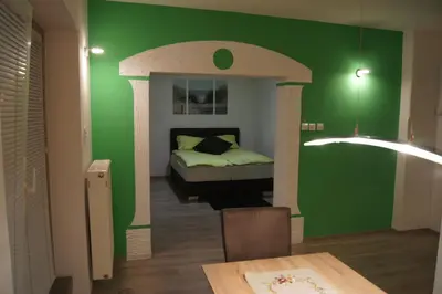 a bedroom with a green wall and a bed at Domas RD Apartment in Ljubljana