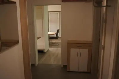 a hallway with a table and a chair in a room at Domas RD Apartment in Ljubljana