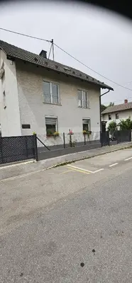 a white house with a fence and a street at Domas RD Apartment in Ljubljana