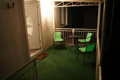 a room with green chairs and a table on a balcony at Domas RD Apartment in Ljubljana