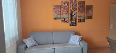 a living room with a couch and paintings on the wall at Alpes in Radovljica