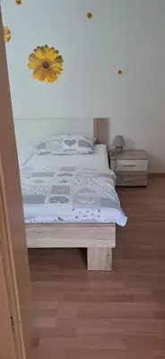 a bedroom with a bed with a sunflower on the wall at Alpes in Radovljica
